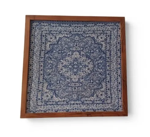A framed blue and white medallion textile in a wooden frame
