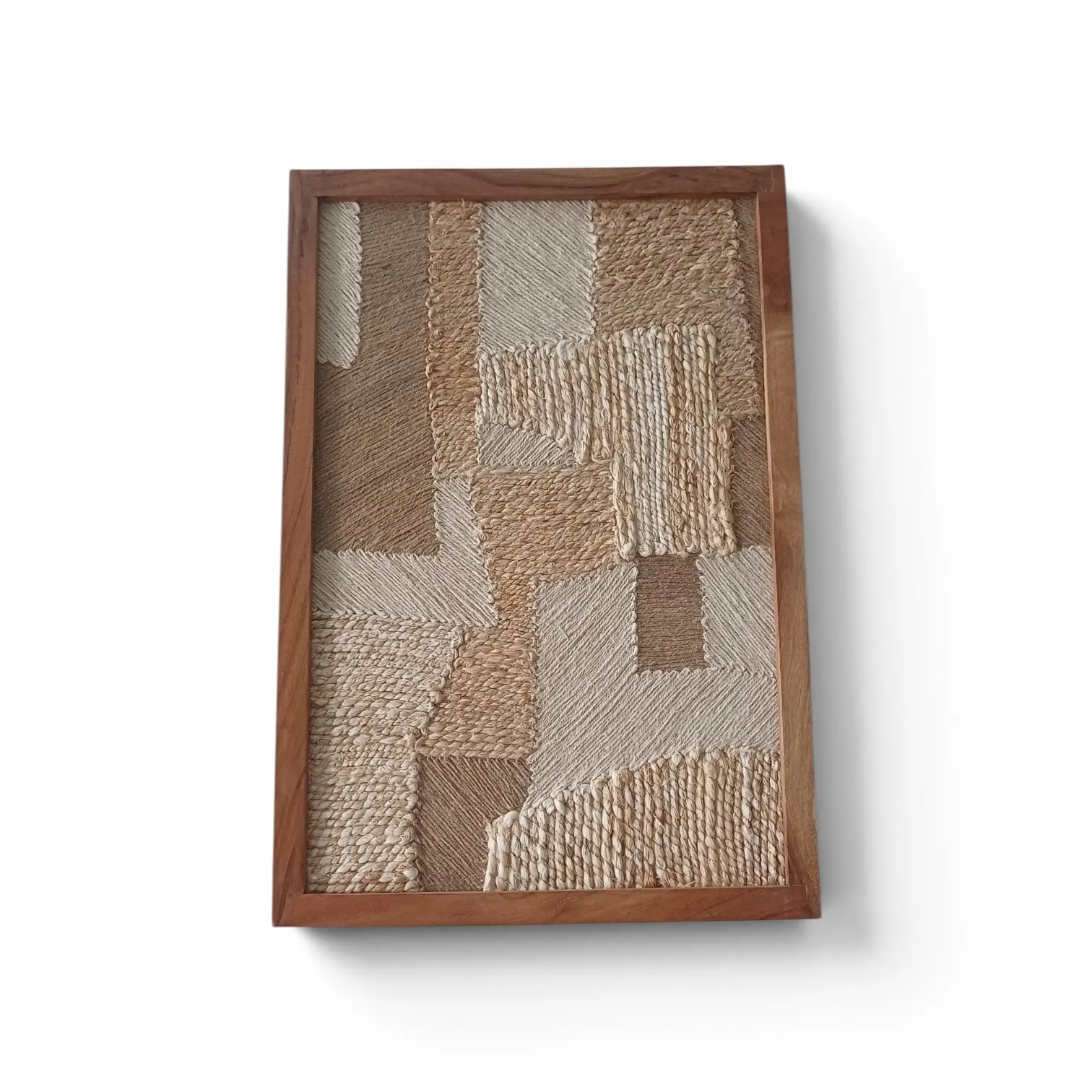 A framed patchwork of hand-woven textures in sand, cream and natural tones, in a wooden frame