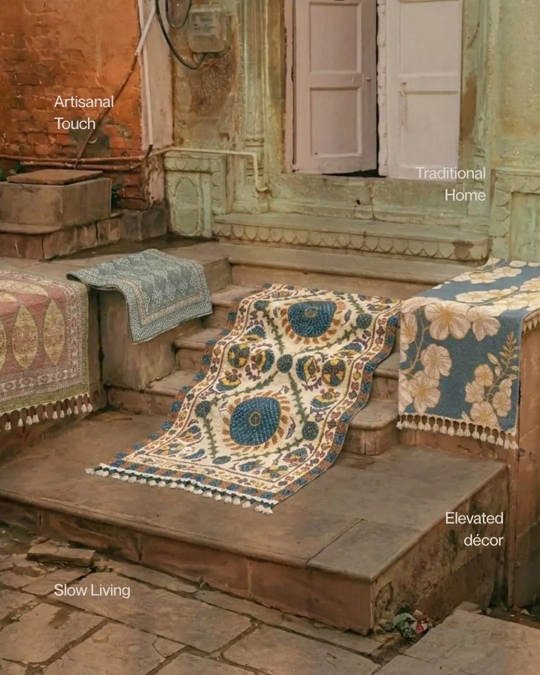 Floral runners in cream, blue and peach laid across old stone steps in front of a carved doorway, with the words Artisan touch, Traditional home, Elevated decor and Slow living